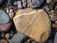 Sandfarbener Stein mit feiner weißen Maserung